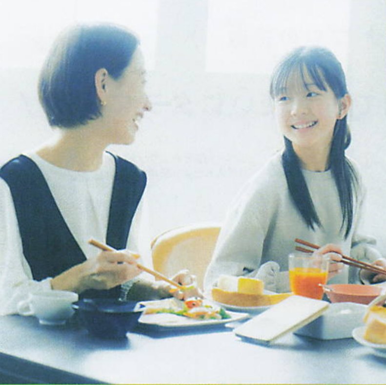 朝の食卓で、料理を囲んで笑い合う親子