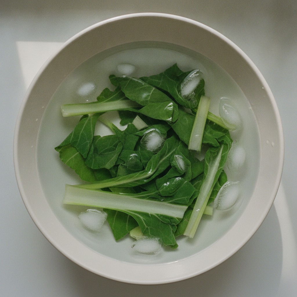 ゆでたのらぼうなを冷水で色止めする様子
